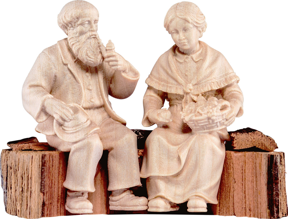 Opa und Oma auf Holzstamm für
