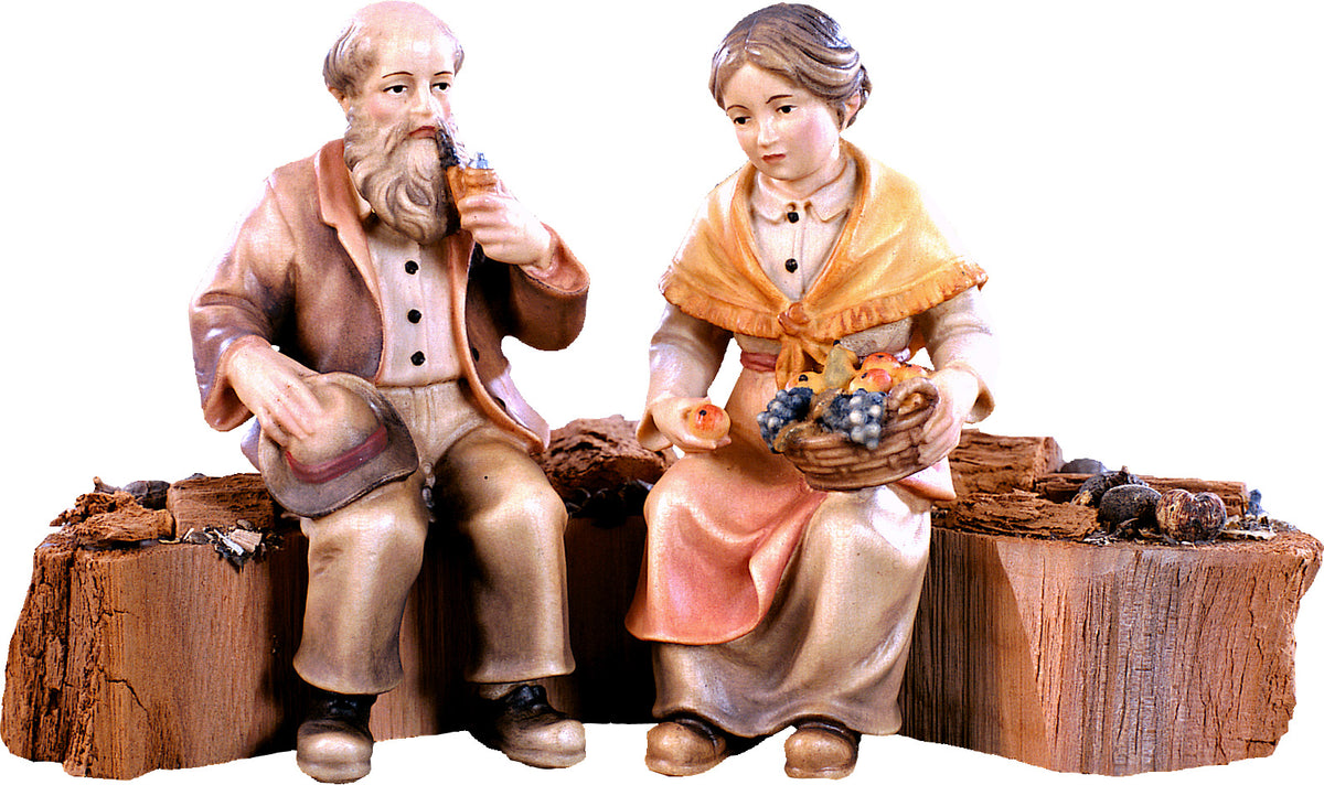 Opa und Oma auf Holzstamm für